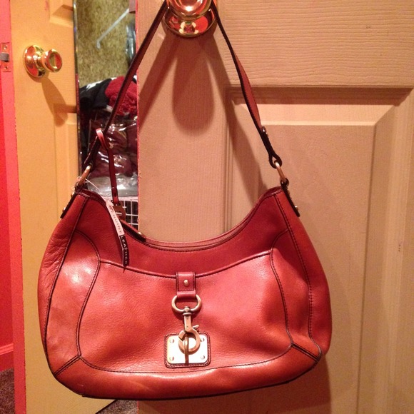 Brown leather handbag with buckle embellishment.
