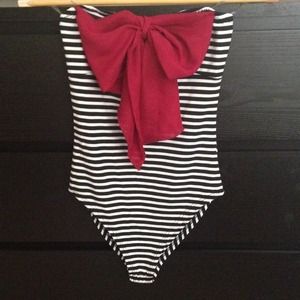 Strapless strip body suit with red bow