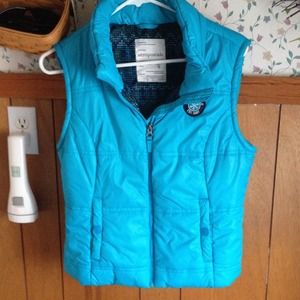 Light blue vest, zip-up with two front pockets.
