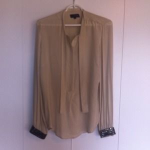 Silky cream blouse with jewel cuffs.