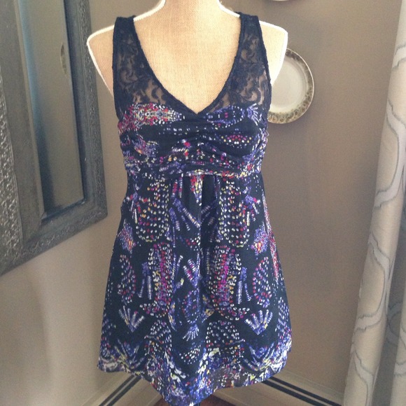 Sleeveless top with lace detail and floral accent