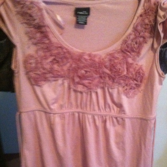 Pink flower ruffles on the top. Ties in the back