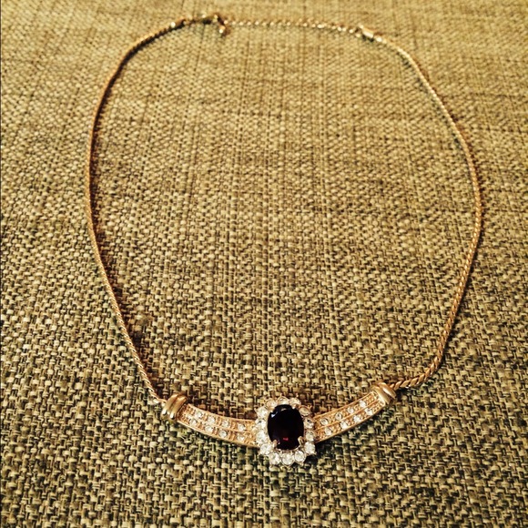 Gold color necklace with purple stones.