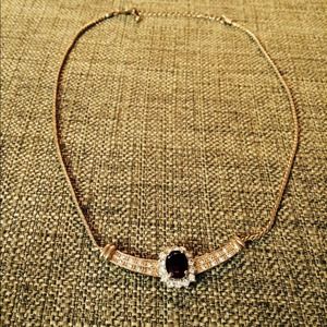 Gold color necklace with purple stones.