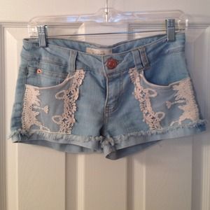 Light wash denim shorts with lace overlay pockets