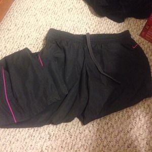 Dark grey Nike wind pants with hot pink accent