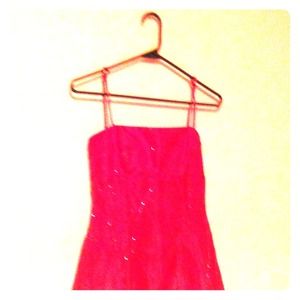 A pink long dress with jewels and 1 strap in back.
