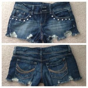 Distressed denim shorts with stud details.