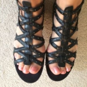 Black gladiator sandals with studs.