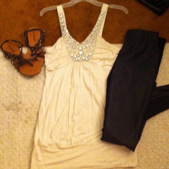 A cream colored tank with silver embellishments