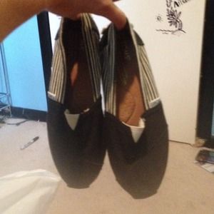 Black and white striped TOMS slip on shoes
