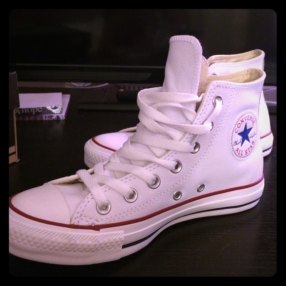 White leather high top Chuck Taylor sneakers.