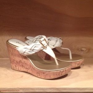 White thong platform sandals with gold buckle.