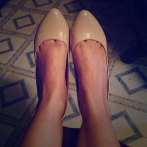 Glossy beige pointy flats.