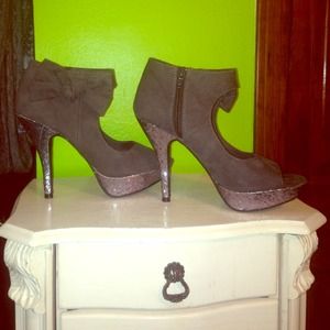 Grey high heels with a bow and glitter bottoms.