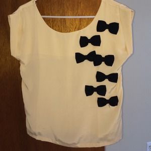 Dressy beige top with black bows.