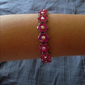 A pink flower bracelet with white crystals