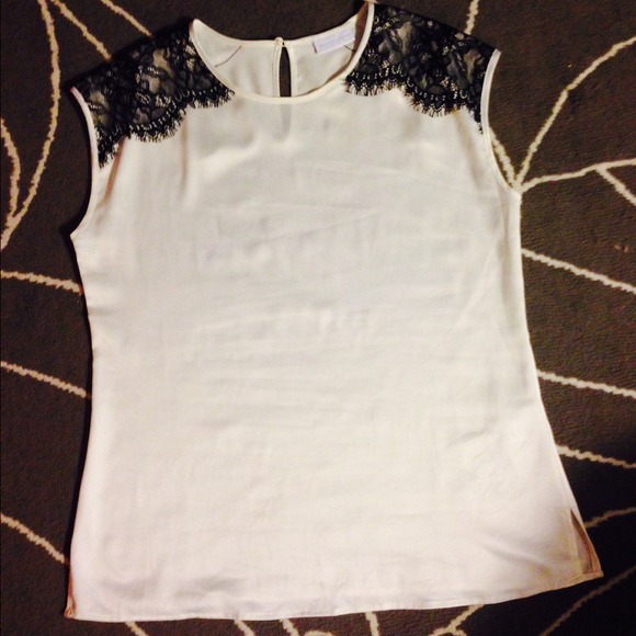 Cream silky top with black lace detail.