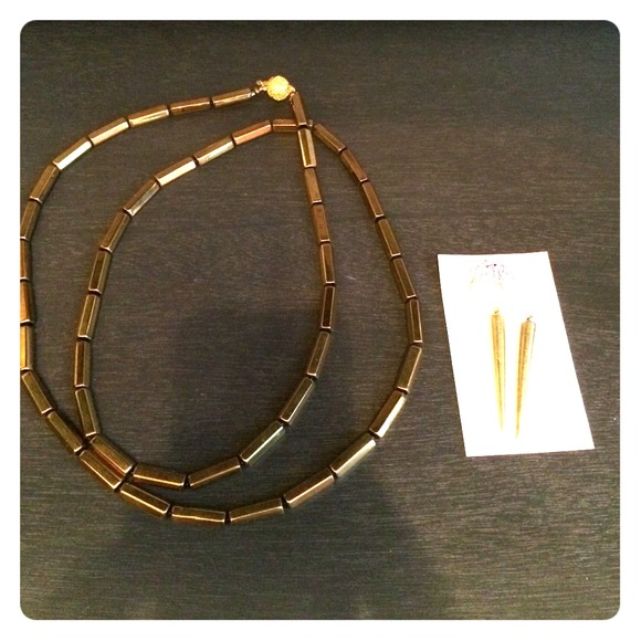 A gold necklace and gold earrings with pearls.