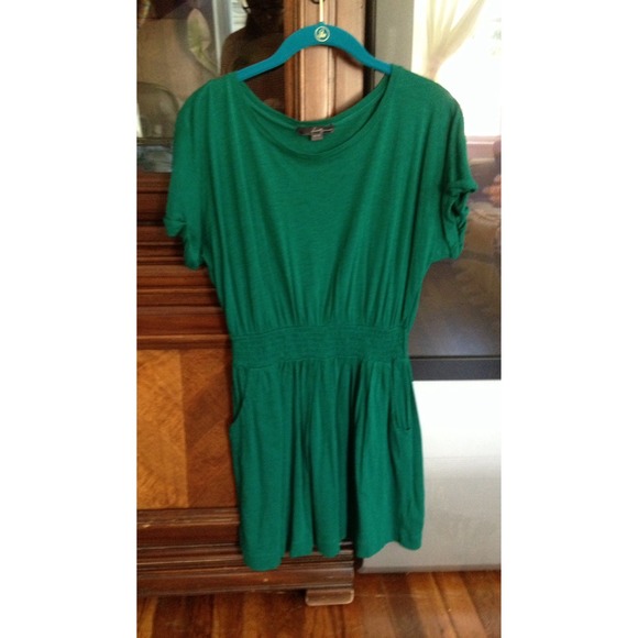 Emerald green dress, cinched in waist, and pockets