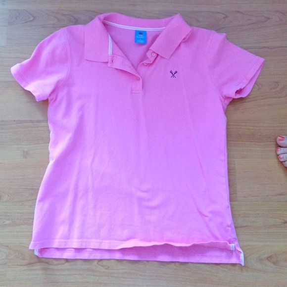 Pink polo with navy lacrosse sticks on chest