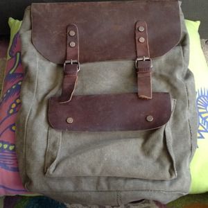 Green canvas backpack with brown leather flaps