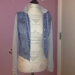 Jean jacket with grey sleeves.