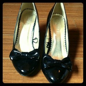 Black patent triangle heels with bow accents