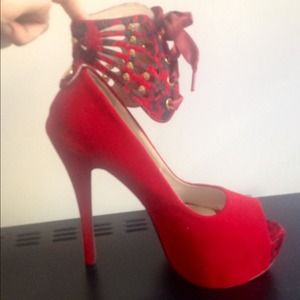 Suede red pumps with lace up ankle straps.