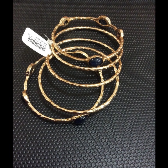 Pack of 4 gold plated bangles. With black accents.