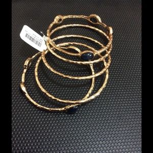 Pack of 4 gold plated bangles. With black accents.