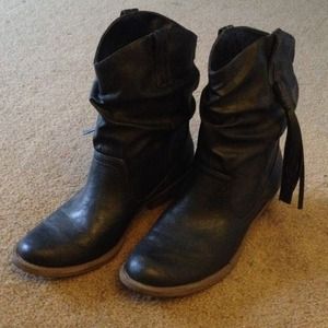 Ankle cowboy boots, with tassels on the outside.