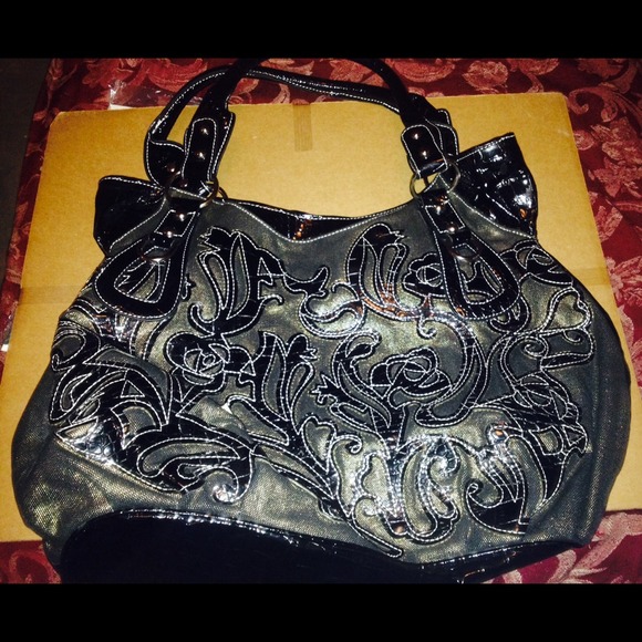 Black patten leather purse with designs.