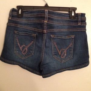 Dark denim BEBE shorts with gold B's on the back