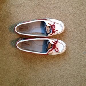 White sperries with red laces and navy anchor side