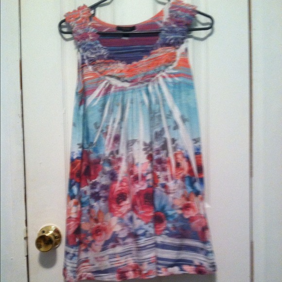 A multi colored tank top with ruffled flowers.
