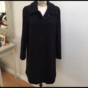 Black swing coat with patented leather details.