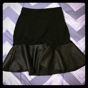 Black mini skirt with faux leather hemming.