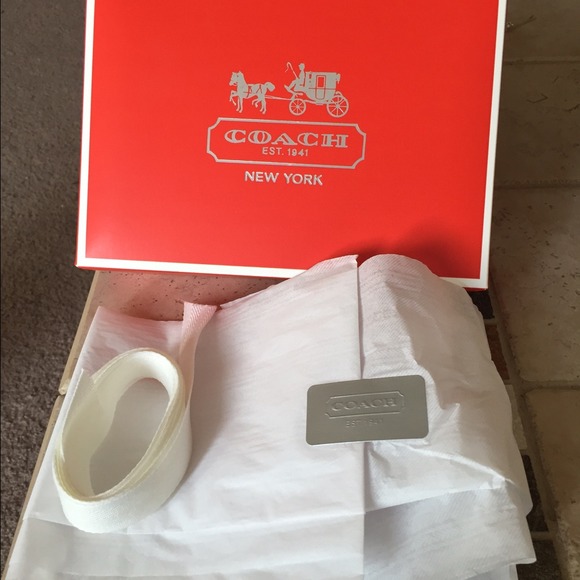 Red coach box with tissue paper and ribbon