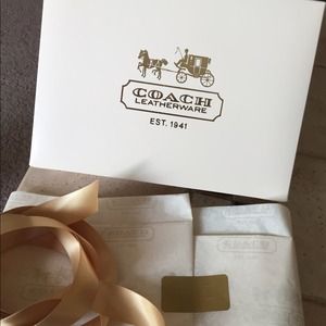 Coach box with tissue paper and gold bow