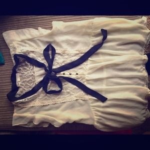 Sleeveless sheer ivory and black blouse.