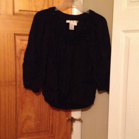 Black top with beading trim around the neck area