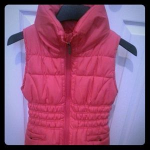 Pink puffer vest jacket with front pockets.