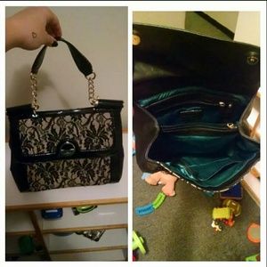 Black purse with lace front and green inside