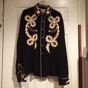A black button up with snaps and beige embroidery