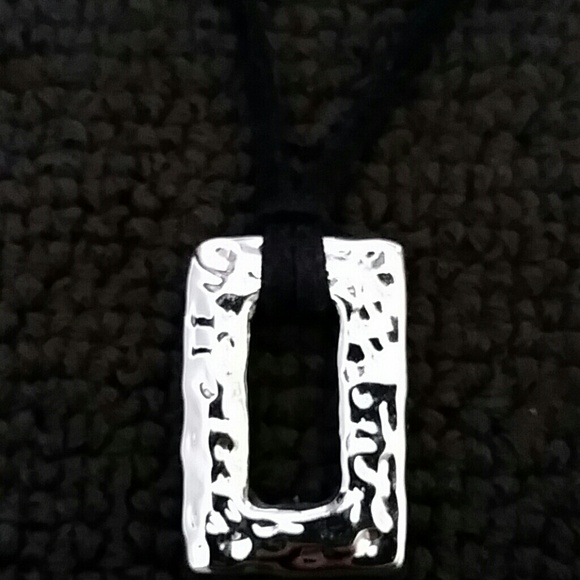 Black leather necklace with silver tone pendant