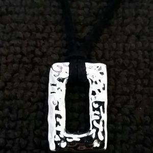 Black leather necklace with silver tone pendant