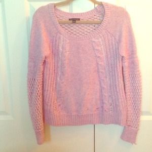 A pink sweater with intricate and unique detail
