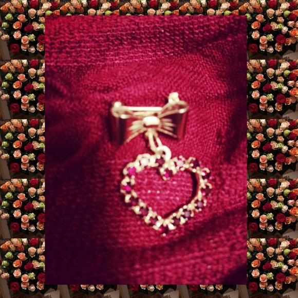 Heart-shaped pin with a bow on top.