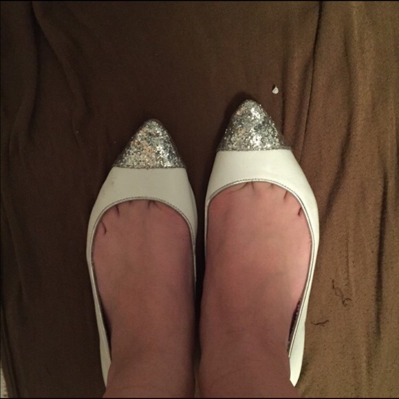 White ballet flats with silver cap toe.
